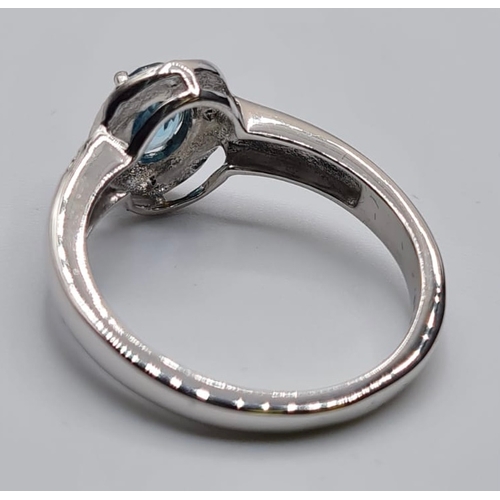 451 - Stone Set Silver Ring Having a Centre Stone the Colour of Blue Topaz, Oval Faceted Form, Size P/Q.