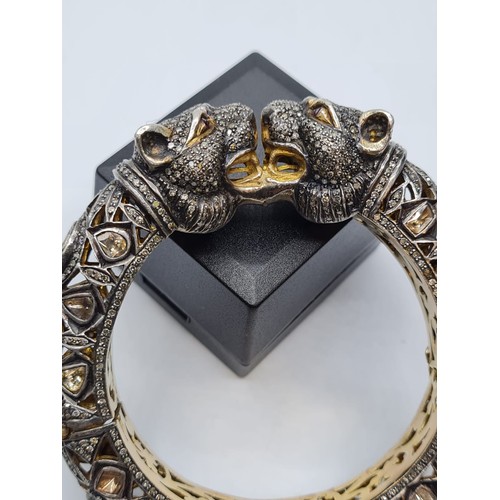 24 - An antique Cartier style yellow and white gold tigers head bangle encrusted with diamonds and comple... 