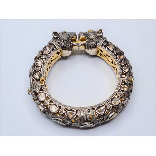 24 - An antique Cartier style yellow and white gold tigers head bangle encrusted with diamonds and comple... 