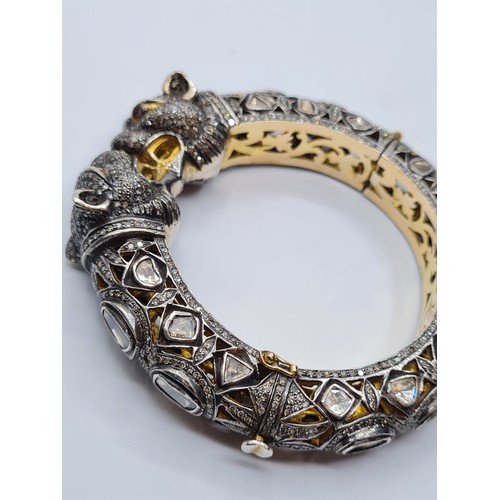 24 - An antique Cartier style yellow and white gold tigers head bangle encrusted with diamonds and comple... 