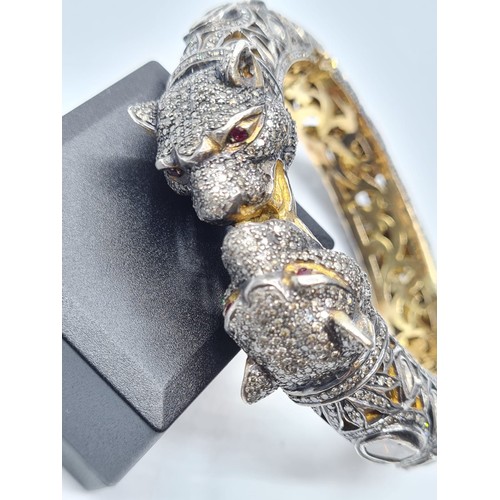 24 - An antique Cartier style yellow and white gold tigers head bangle encrusted with diamonds and comple... 