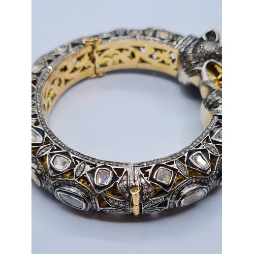 24 - An antique Cartier style yellow and white gold tigers head bangle encrusted with diamonds and comple... 