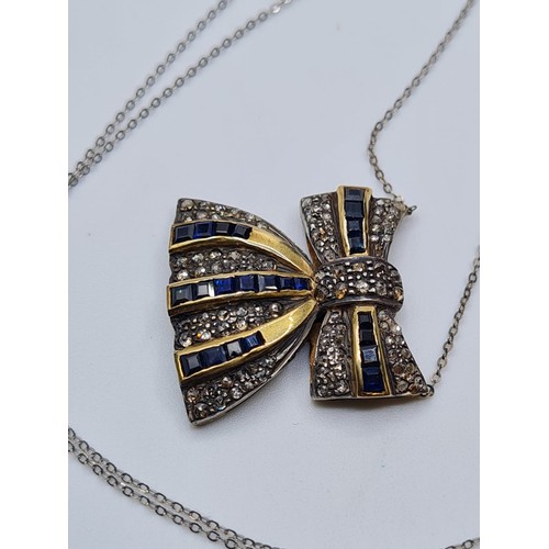 393 - A silver and gold diamond encrusted Sapphire bow, weight 6.5g 7 & length 40cms