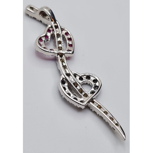 505 - 18ct white gold double heart pendant with diamonds and ruby's, weight 5.4g & length 5cms