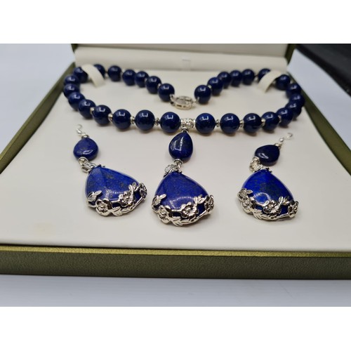 65 - A lapis lazuli and white metal (stamped 925) necklace and matching earrings set in a presentation bo... 