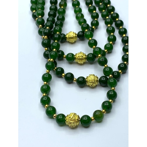 103 - A four row dark green jade necklace with gold filled ornamental beads. Length: 56-70 cm. Weight: 198... 