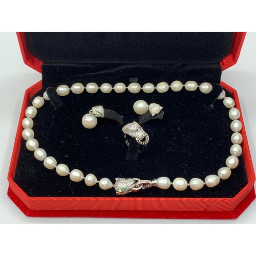 24 - A white pearl necklace, earrings and ring  set  in the Cartier Style. In original presentation box. ... 