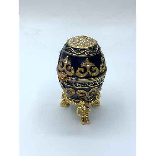 56 - A yellow and white metal ring with gems in the form of a highly ornate. snake presented in “Faberge”... 