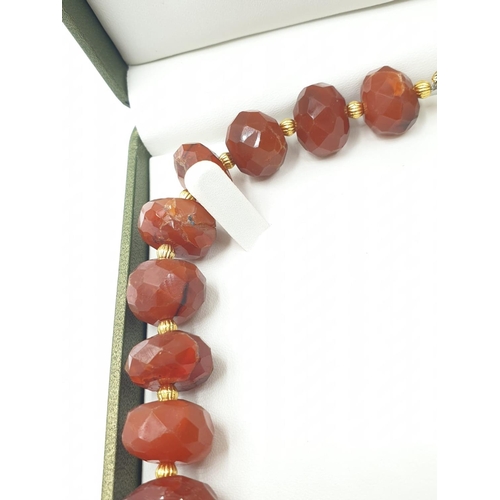 560 - An impressive faceted carnelian necklace and earrings set with gold filled spacer beads in a present... 