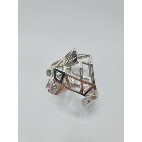 562 - An Art Deco, white metal (untested) Panther lattice ring with green emerald eyes, in the Cartier sty... 