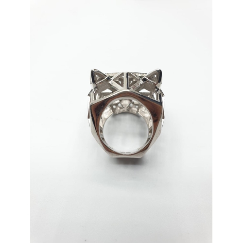 562 - An Art Deco, white metal (untested) Panther lattice ring with green emerald eyes, in the Cartier sty... 