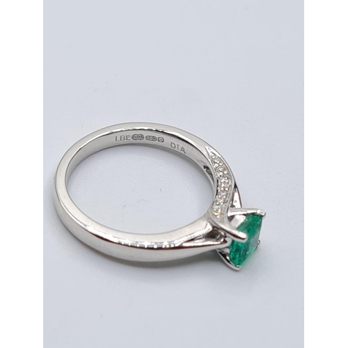 37 - 18ct white gold emerald single stone ring with diamonds set on side of setting, weight 3.3g with 0.4... 