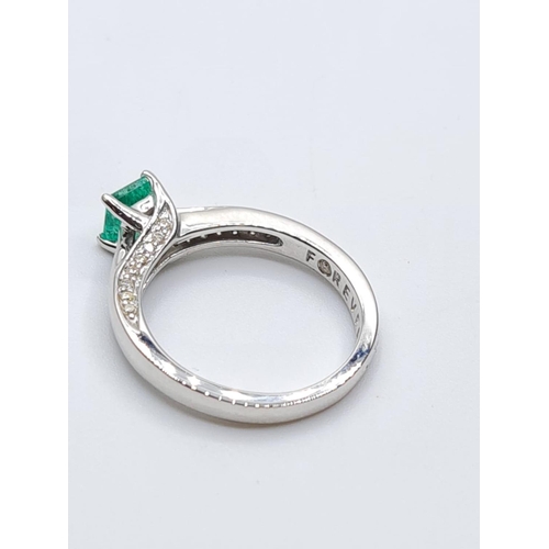 37 - 18ct white gold emerald single stone ring with diamonds set on side of setting, weight 3.3g with 0.4... 