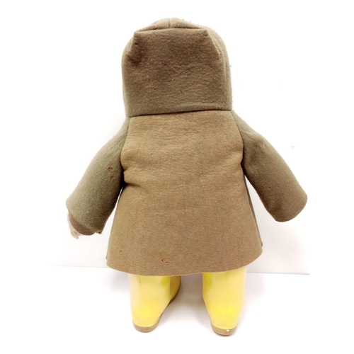 571 - An original 1970s Paddington bear in green felt coat, label and yellow Dunlop wellington boots. Stit... 