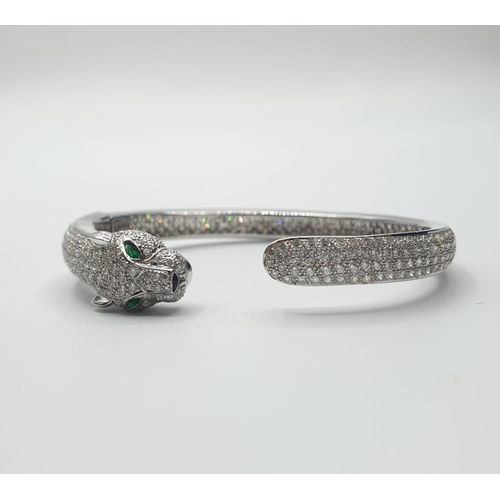 48 - Cartier style 18ct gold bangle with emerald eyes. weight 21.2g