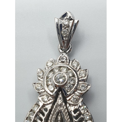 83 - 18ct white gold and diamond Buddha pendant. weight 18.1g and 4cm drop