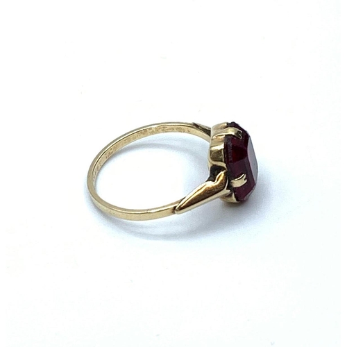 620 - 9ct gold ring with large dress stone in four claw mount. Pale garnet colour, size M