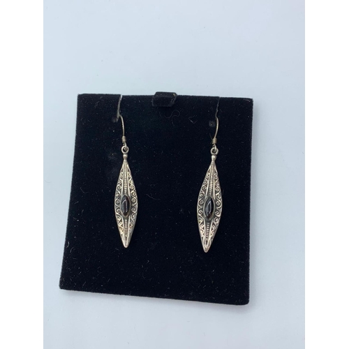 644 - Silver earrings marquise shape with scroll design having black onyx stones to top. Presented in attr... 