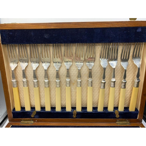 663 - 24 piece set of cutlery in original wooden canteen. Consisting 12 fish knives and 12 forks with silv... 