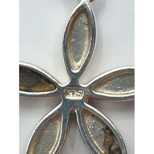 549 - Silver pendant having mother of pearl and black onyx set in flower form and presented on a silver ch... 