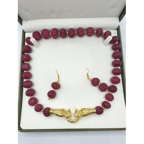 122 - A large beaded, hand carved, gourd shaped, ruby necklace with gold filled dragon heads clasp and mat... 