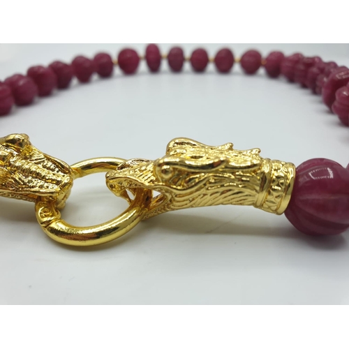 122 - A large beaded, hand carved, gourd shaped, ruby necklace with gold filled dragon heads clasp and mat... 