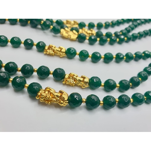 74 - A three row, Chinese necklace, faceted, dark green, jade with gold filled PIXIUs. Length: 61 – 67cm.... 