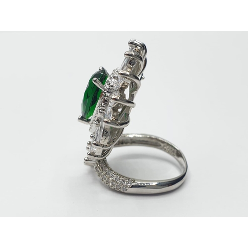 96 - An impressive silver (stamped S925) with green and clear gems. Ring size: N. In a presentation box.