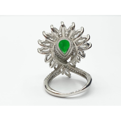 96 - An impressive silver (stamped S925) with green and clear gems. Ring size: N. In a presentation box.