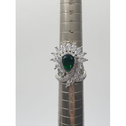 96 - An impressive silver (stamped S925) with green and clear gems. Ring size: N. In a presentation box.