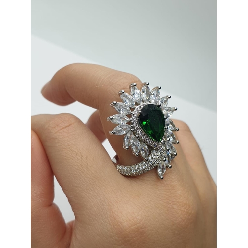 96 - An impressive silver (stamped S925) with green and clear gems. Ring size: N. In a presentation box.