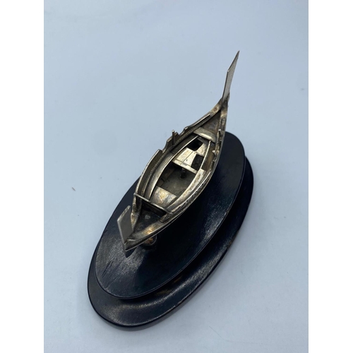 543 - Silver Viking longboat mountain and wooden plinth, 12cm long and 7cm high