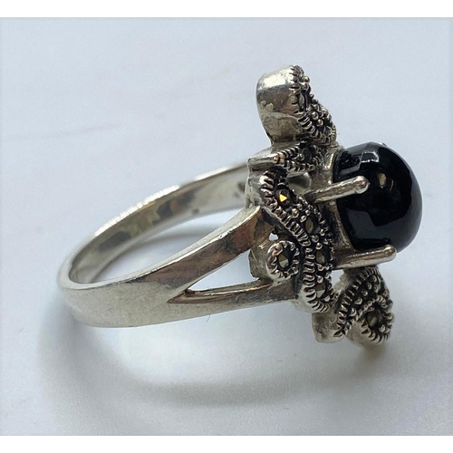 190 - Silver RING having marcasite work to top with black onyx cabochon sit in a four claw raised mount.  ... 