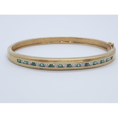 2 - 18CT Y/G DIAMOND & EMERALD BANGLE CHANNEL SET, WEIGHT 20G WITH 0.25CT DIAMONDS & 0.60CT EMERALD APPR... 