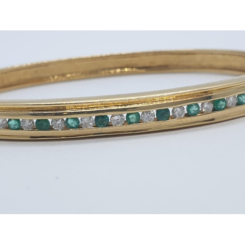 2 - 18CT Y/G DIAMOND & EMERALD BANGLE CHANNEL SET, WEIGHT 20G WITH 0.25CT DIAMONDS & 0.60CT EMERALD APPR... 