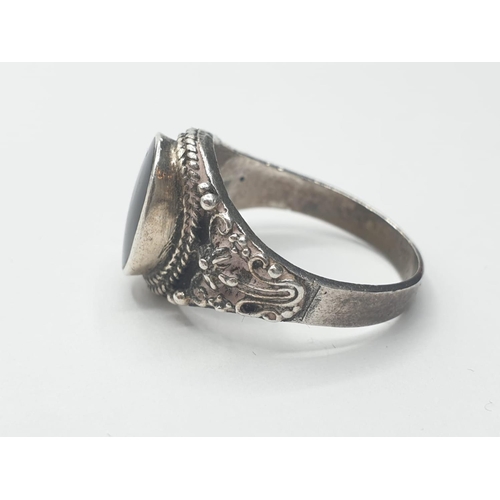 305 - Silver ring having a large black oval onyx stone to top. Intricate gothic silver work to shoulders. ... 