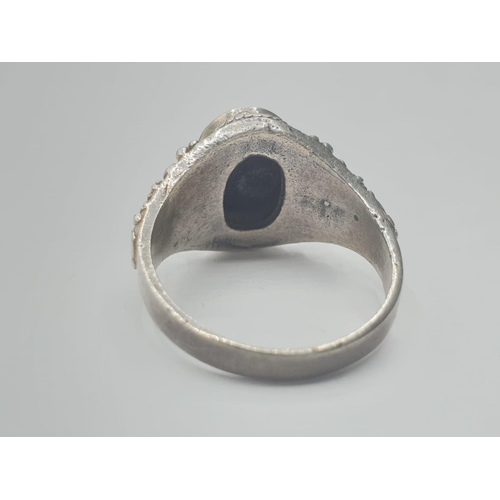 305 - Silver ring having a large black oval onyx stone to top. Intricate gothic silver work to shoulders. ... 