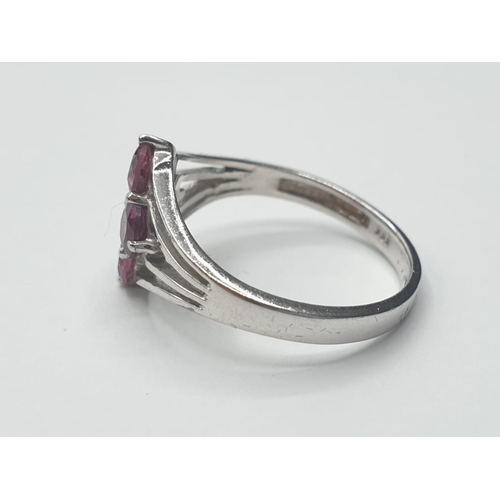 321 - Silver ring having 4 faceted pink 'sapphire' coloured stones to top. Attractive silver strand work t... 