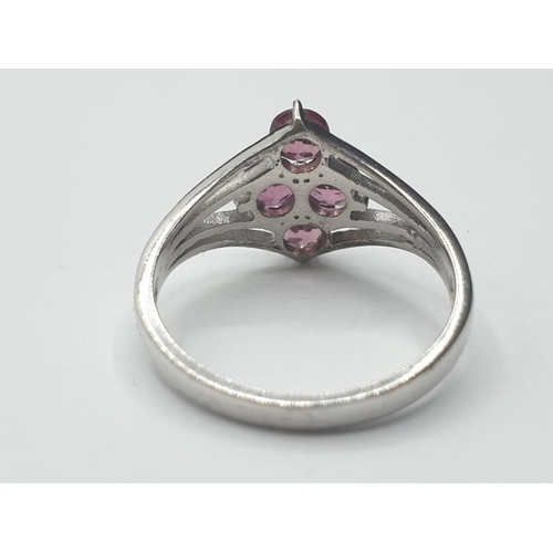 321 - Silver ring having 4 faceted pink 'sapphire' coloured stones to top. Attractive silver strand work t... 