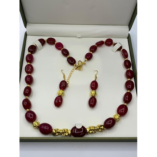 24 - An impressive, large beaded, ruby and gold filled necklace and earrings set in
a presentation box. N... 