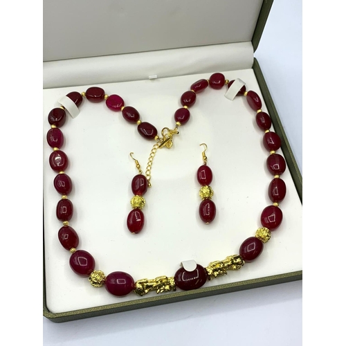 24 - An impressive, large beaded, ruby and gold filled necklace and earrings set in
a presentation box. N... 