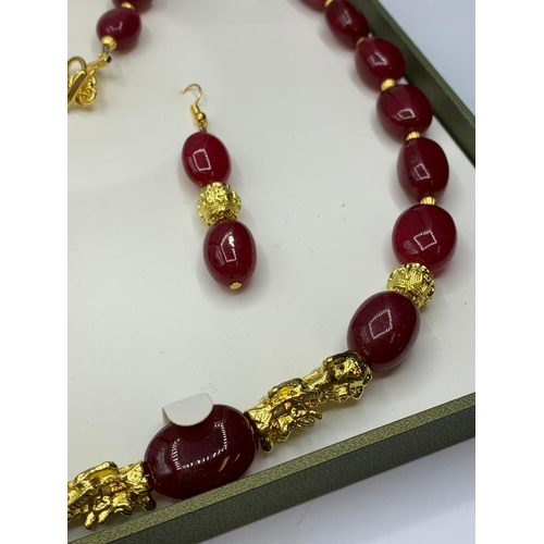 24 - An impressive, large beaded, ruby and gold filled necklace and earrings set in
a presentation box. N... 