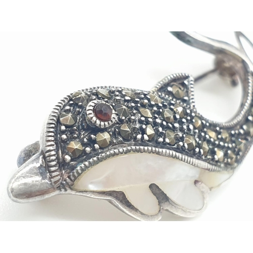 174 - Silver marcasite and mother of pearl dolphin brooch, having a garnet eye with mother of pearl tail a... 