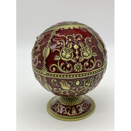 119 - A very ornamental,  global, bronze and dark red enamel, ashtray on a
circular base. Height: 12cm, wi... 