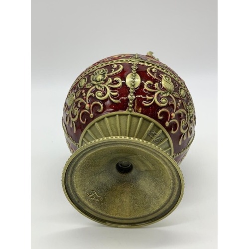 119 - A very ornamental,  global, bronze and dark red enamel, ashtray on a
circular base. Height: 12cm, wi... 