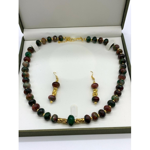 140 - A Chinese multicoloured and multifaceted jade beads with gold filled spacer
beads and pixiu dogs nec... 