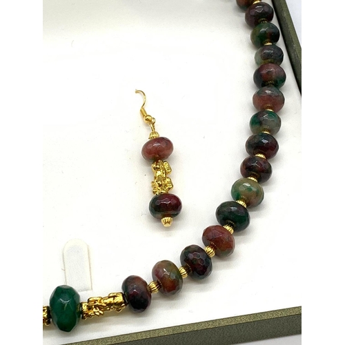 140 - A Chinese multicoloured and multifaceted jade beads with gold filled spacer
beads and pixiu dogs nec... 