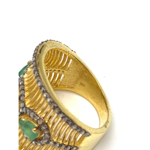 18 - A gold and silver ring with 3 Colombian emeralds and over 150 diamonds
(tested) on parallel, curved ... 