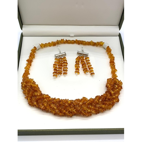 63 - A Baltic amber six row braided necklace and a pair of earrings set in a
presentation box. Necklace l... 