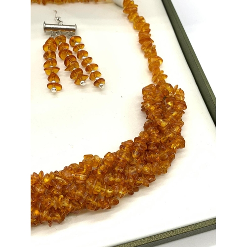 63 - A Baltic amber six row braided necklace and a pair of earrings set in a
presentation box. Necklace l... 